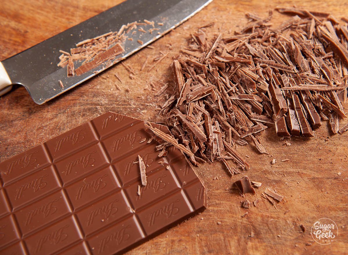 finely chopped milk chocolate bar on a wooden cutting board