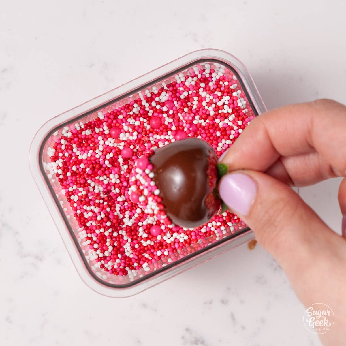 dipping chocolate covered strawberry in spinkles