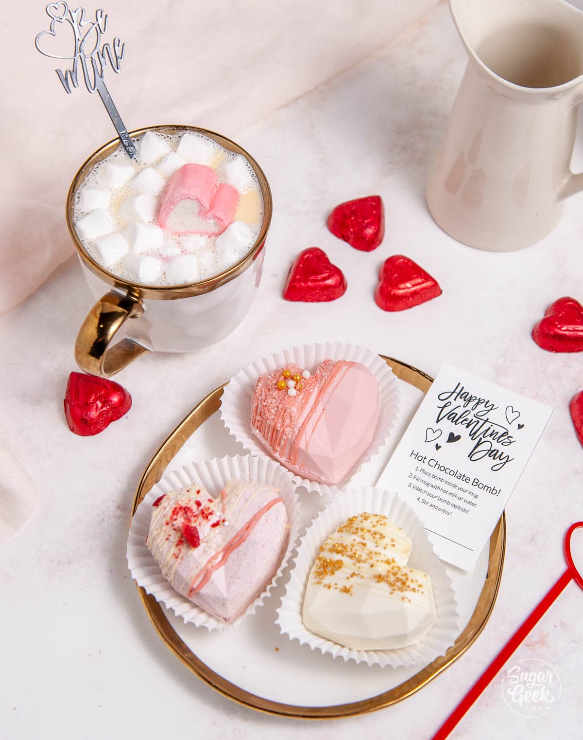 hot chocolate bombs on a plate with a mug behind it