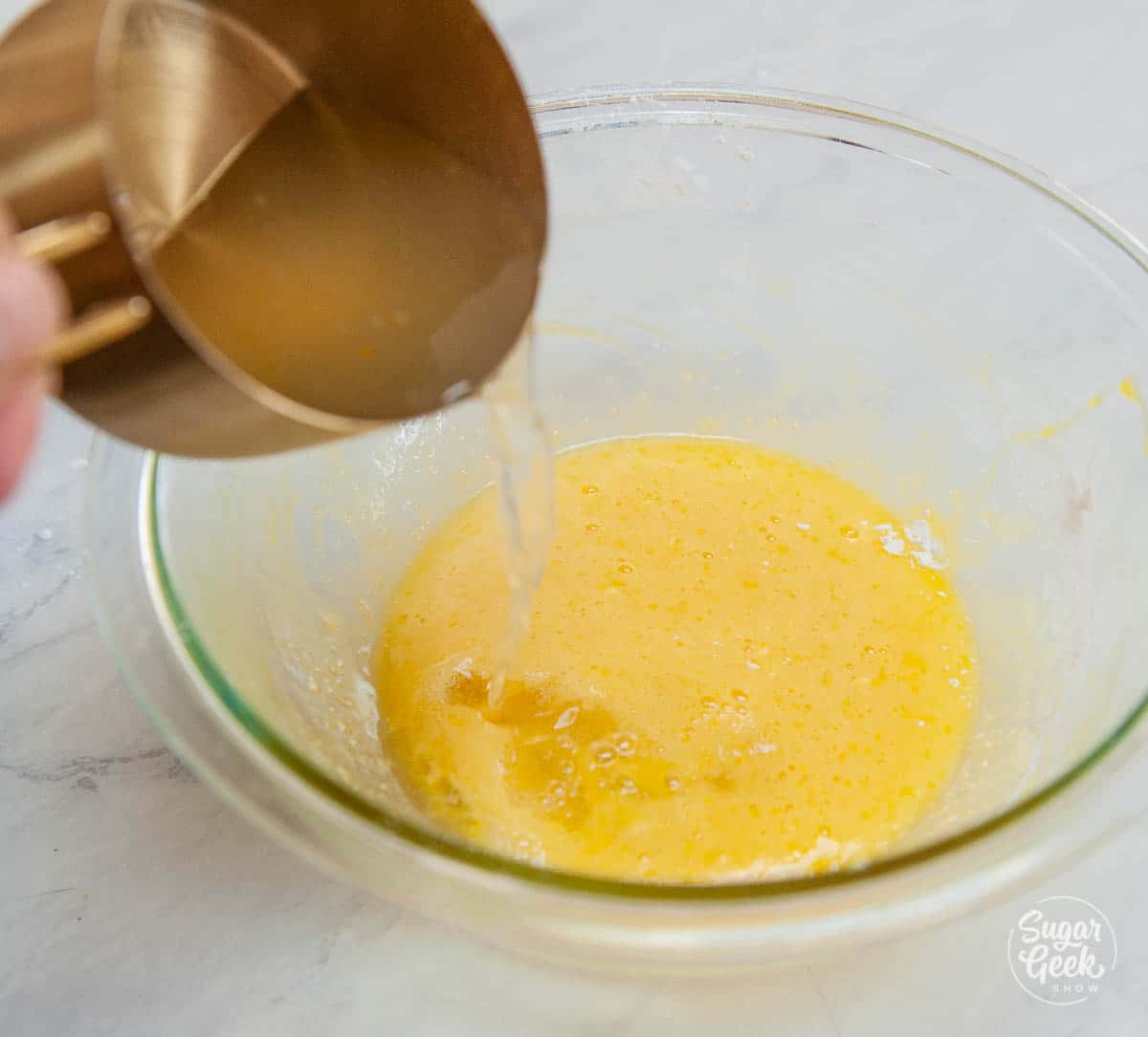 adding hot lemon juice mixture to egg mixture