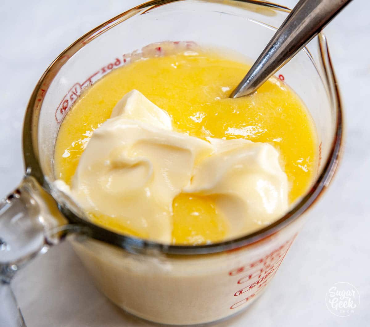 butter on top of lemon curd in a measuring cup