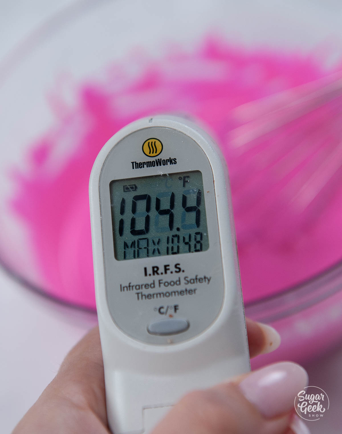 thermometer checking the temp of pink chocolate