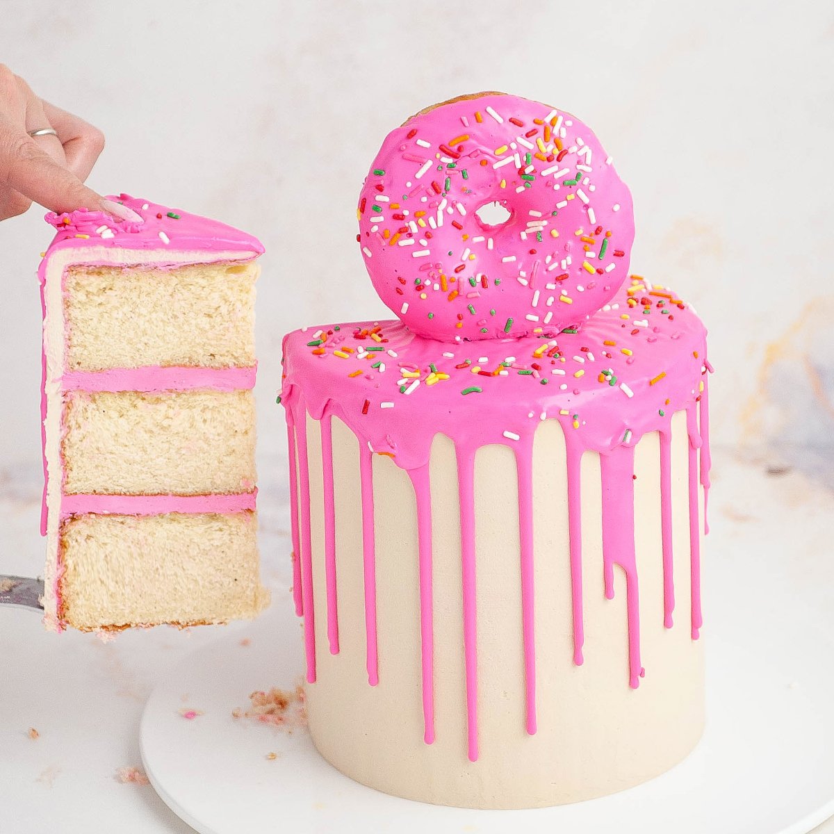 donut cake with hand holding slice