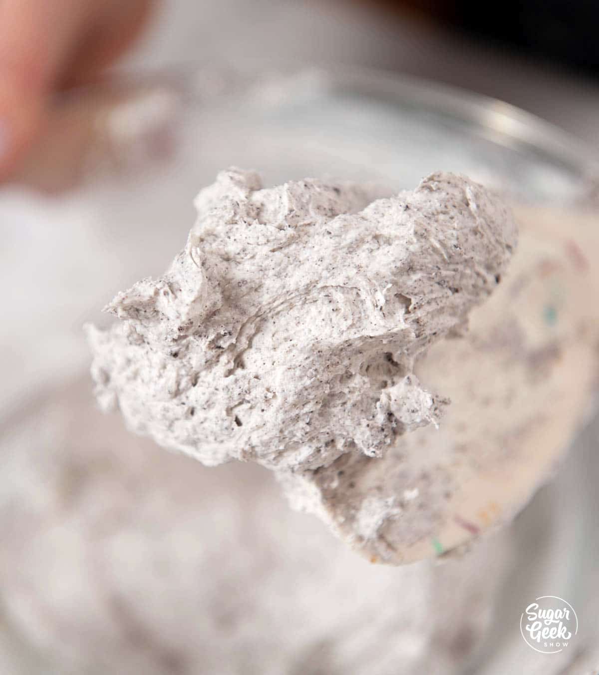 Close up of buttercream frosting mixed with crushed Oreos.