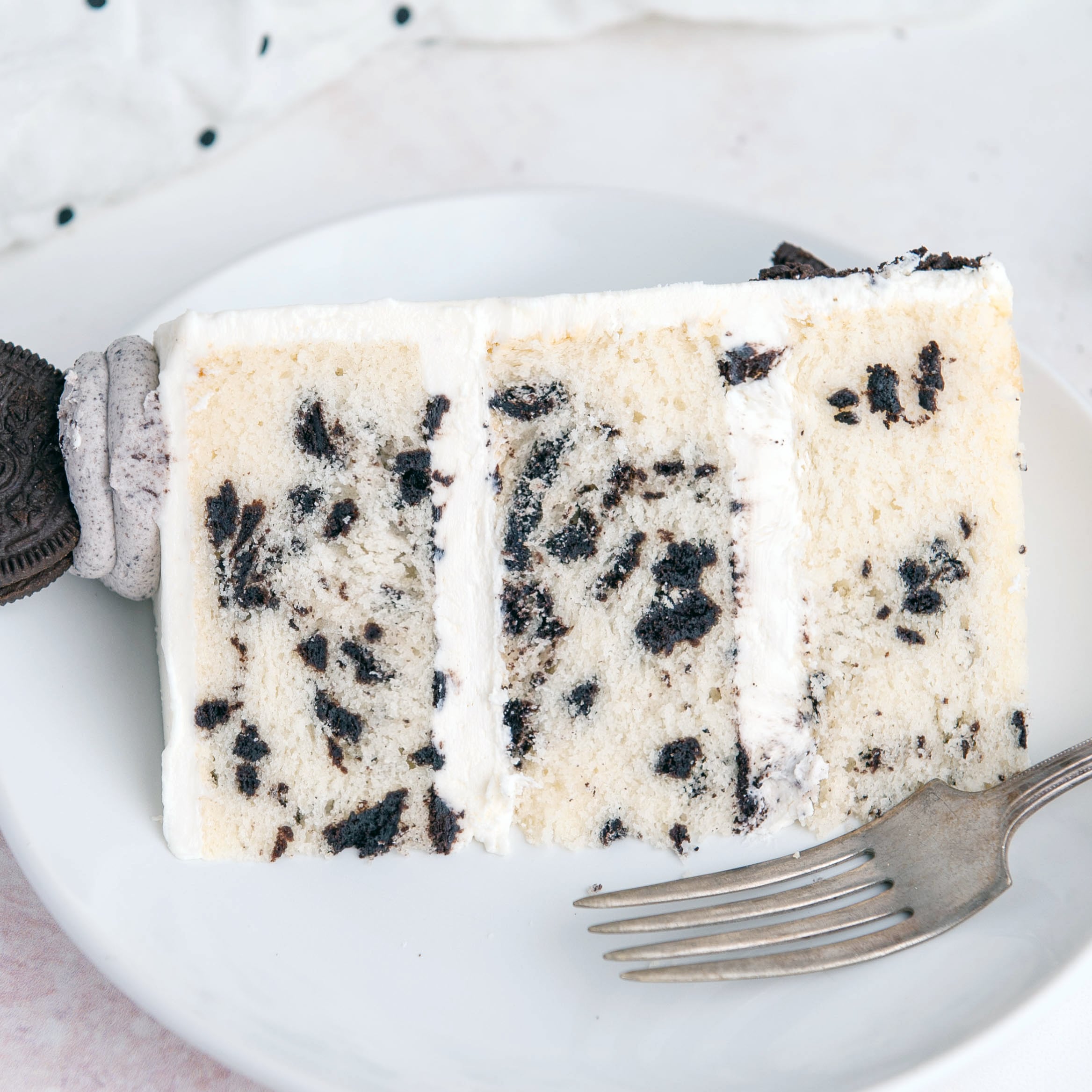 Oreo cake slice on a white plate with a fork.