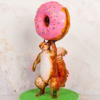 cake sculpted to look like a squirrel holding a giant donut
