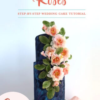 Wedding cake with dark blue tiers, pink wafer paper flowers and hand-painted designs
