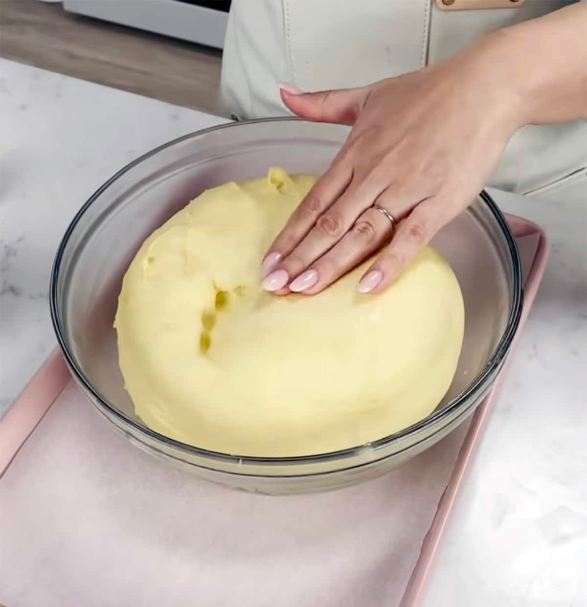 Brioche bread dough in a clear bowl.