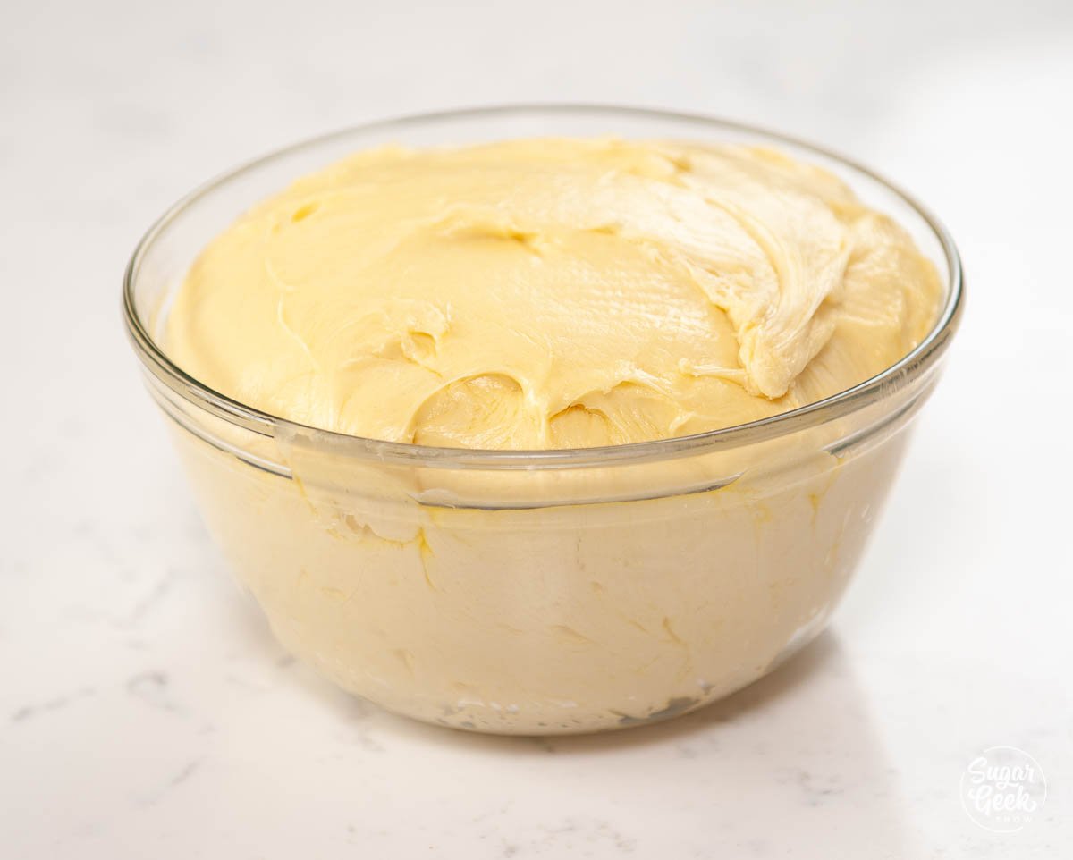 brioche dough in a clear buttered bowl