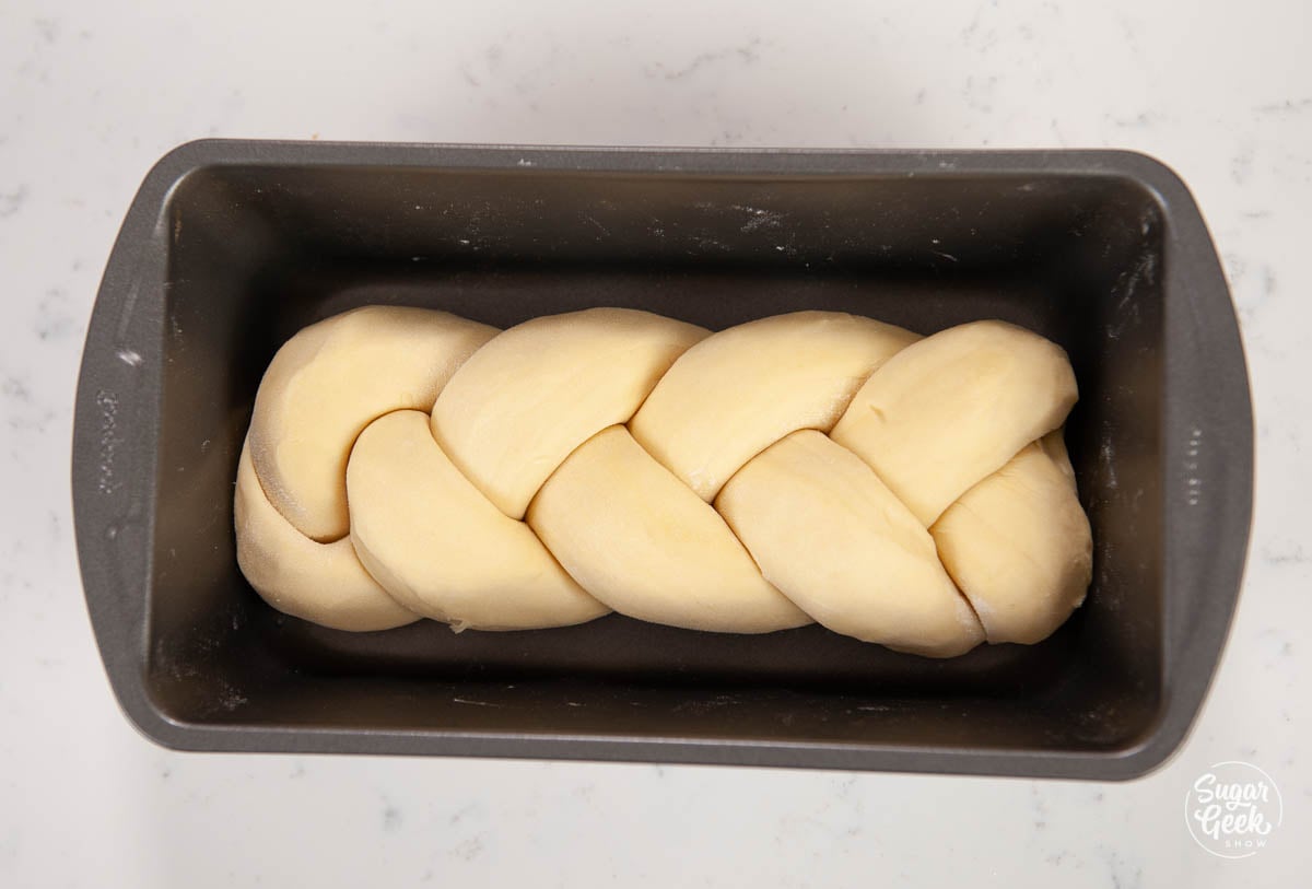 closeup of braided brioche in a bread pan