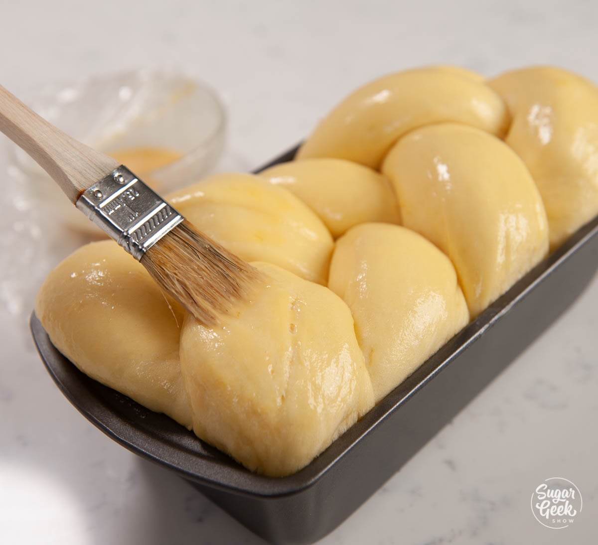 Brushing bread with egg wash.