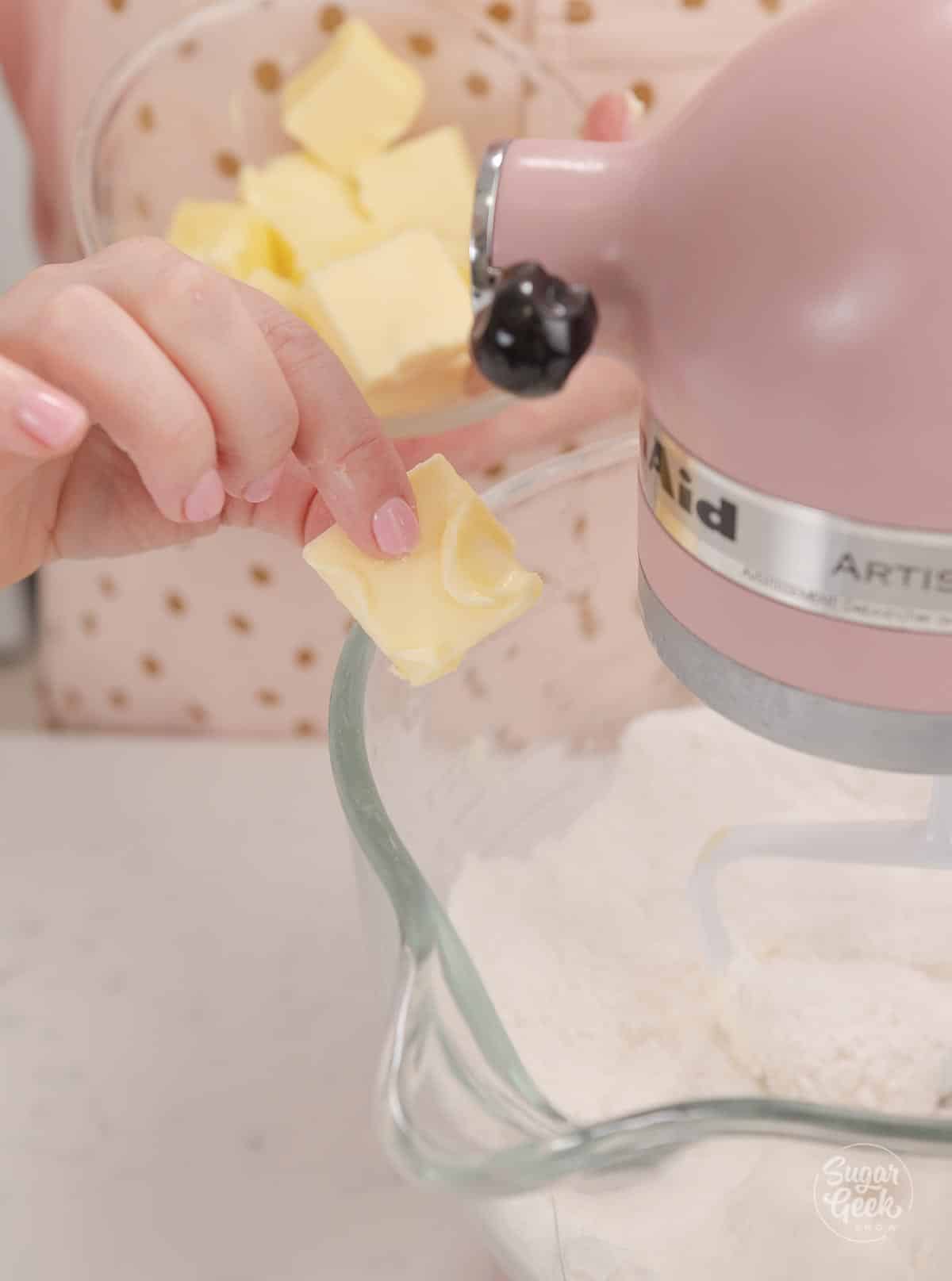 adding butter to flour mixture in a stand mixer