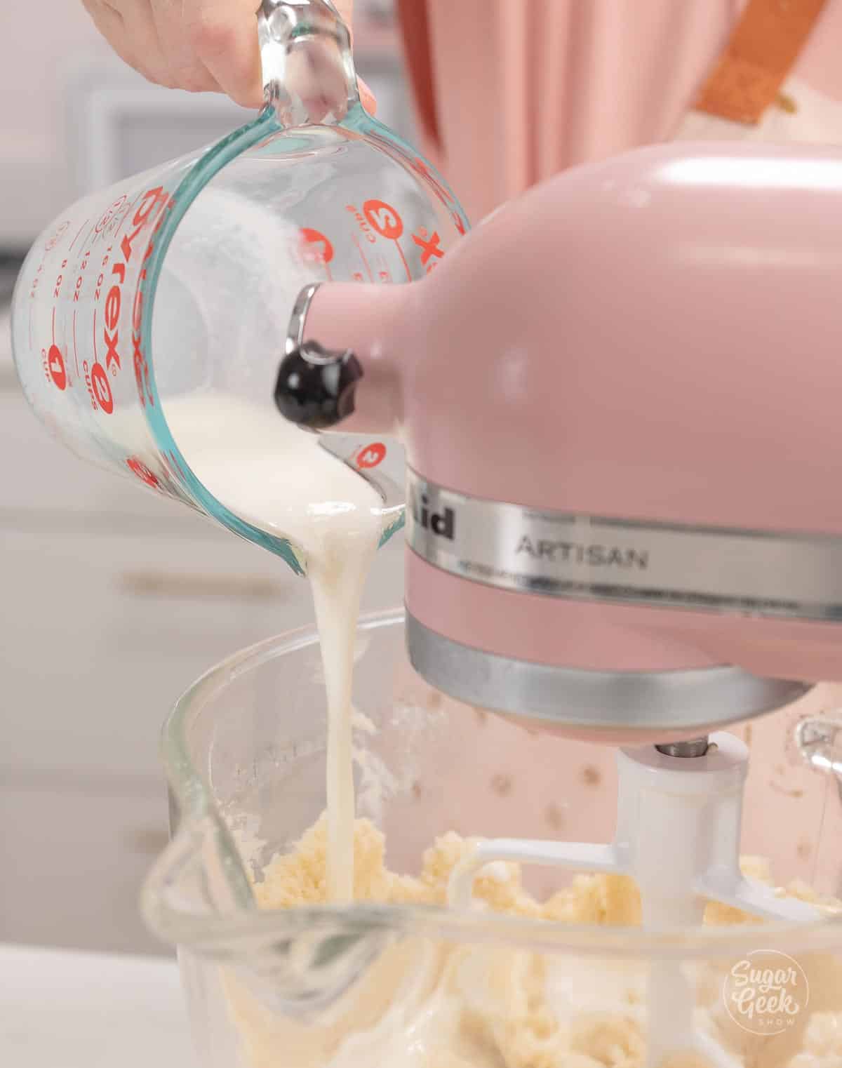 adding milk to dry ingredients in a stand mixer