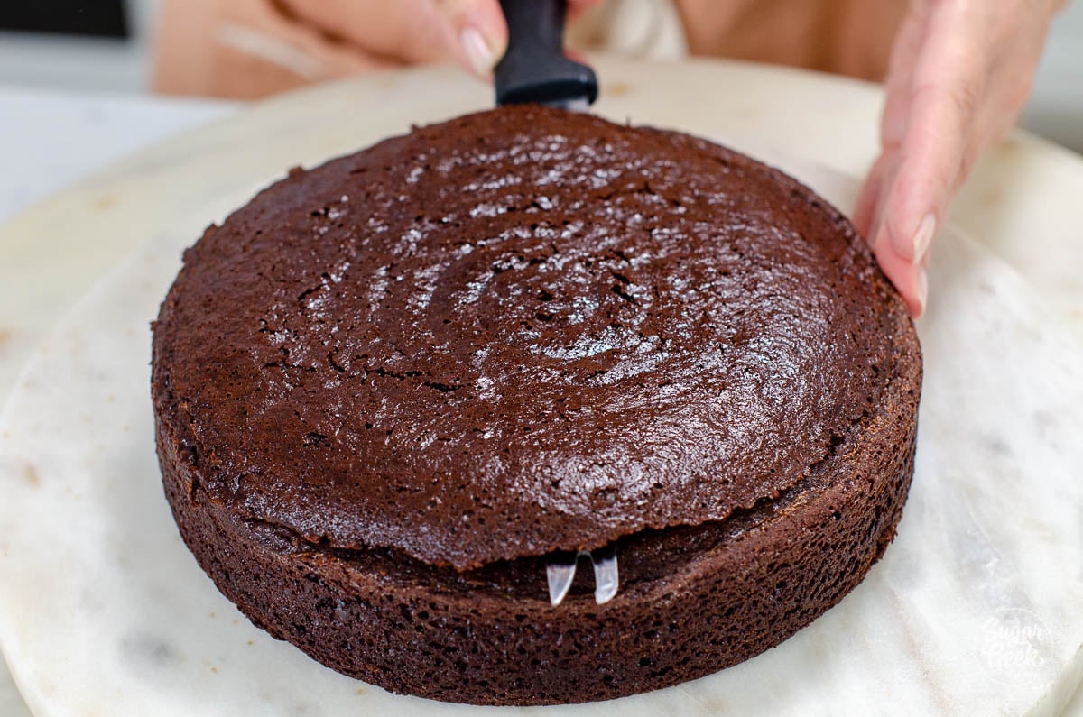 knife cutting through an eggless chocolate cake layer