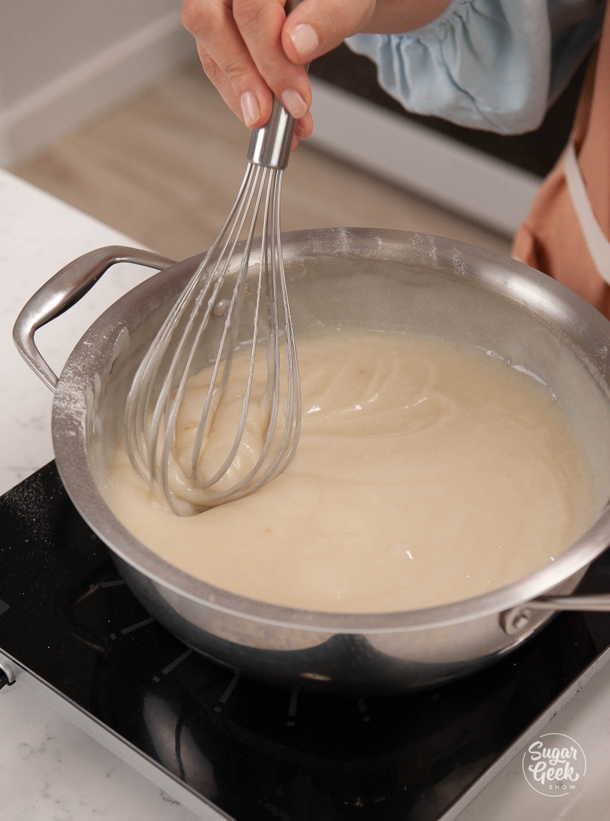 ermine frosting base in a large saucepan with a metal whisk