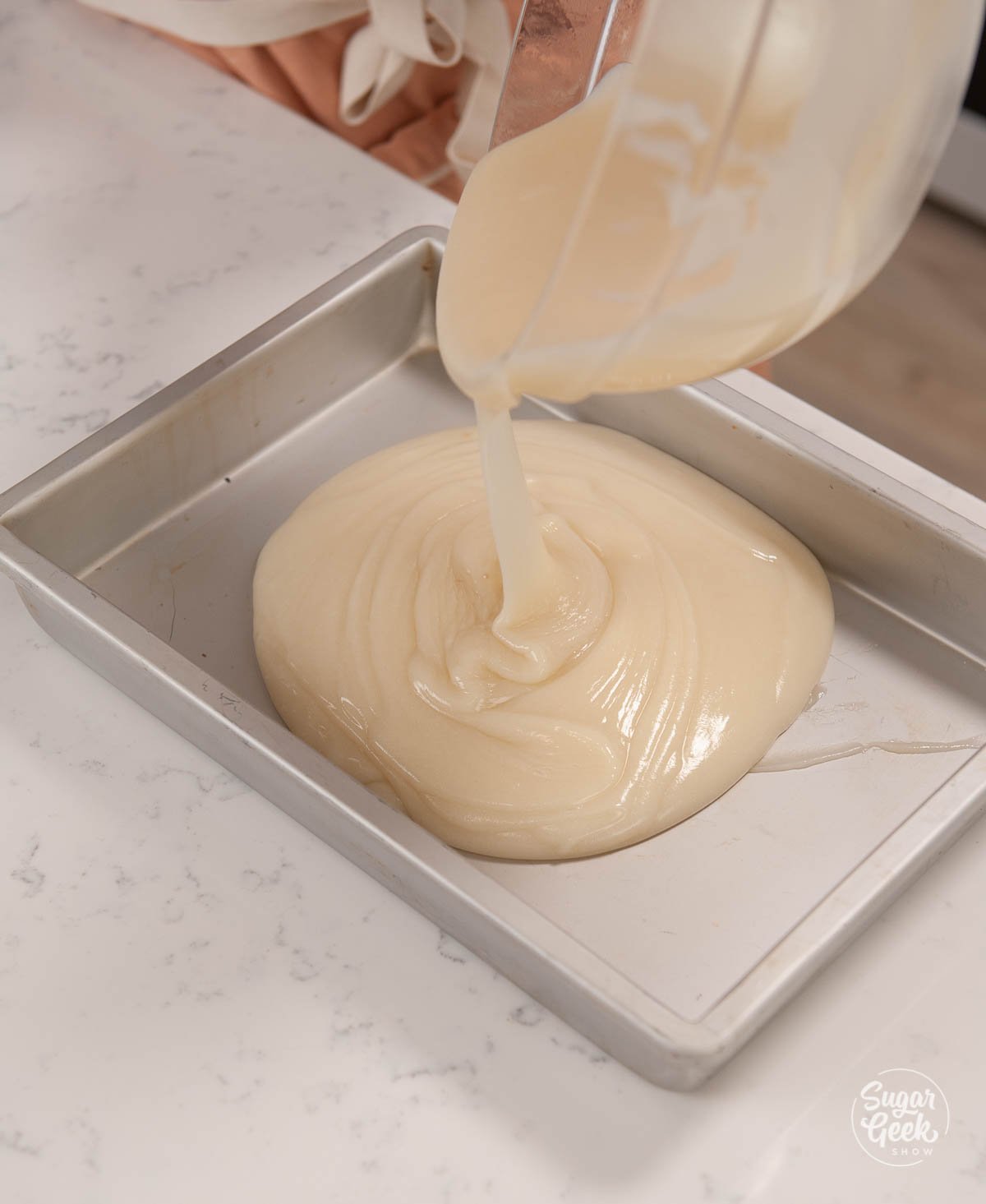pouring ermine frosting base into a shallow cake pan to cool