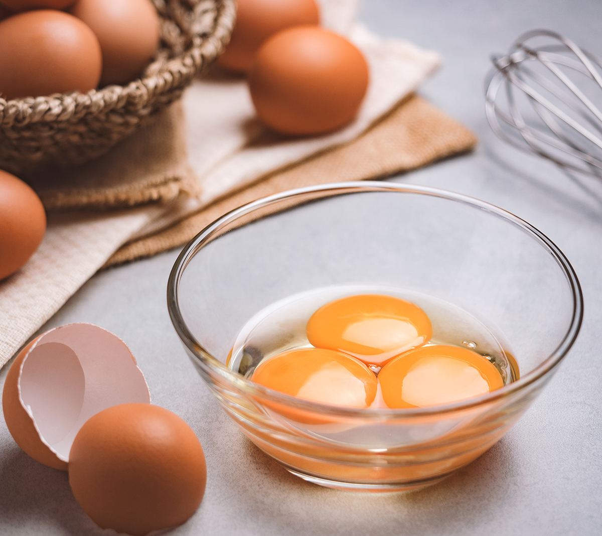 close up of three eggs in a clear bowl