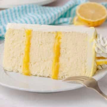 lemon layer cake slice with lemon curd filling and buttercream on a white plate