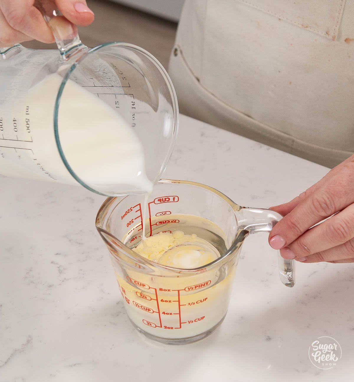 pouring milk into oil in a measuring cup