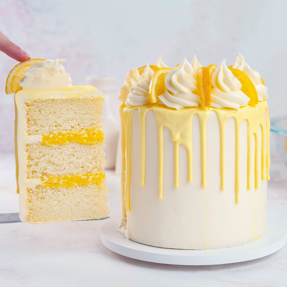slice of lemon cake next to lemon layer cake