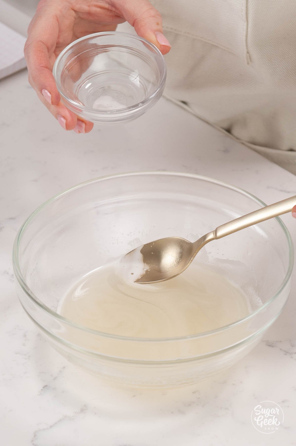 margarita gelatin melted in a clear bowl with a spoon