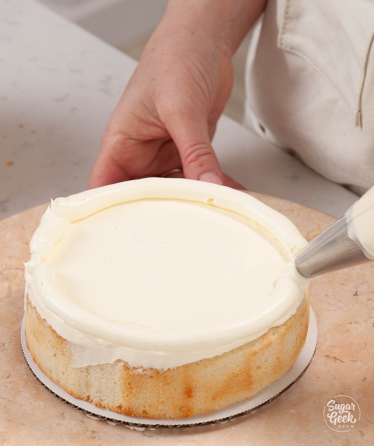 adding a dam of buttercream to the lime cake
