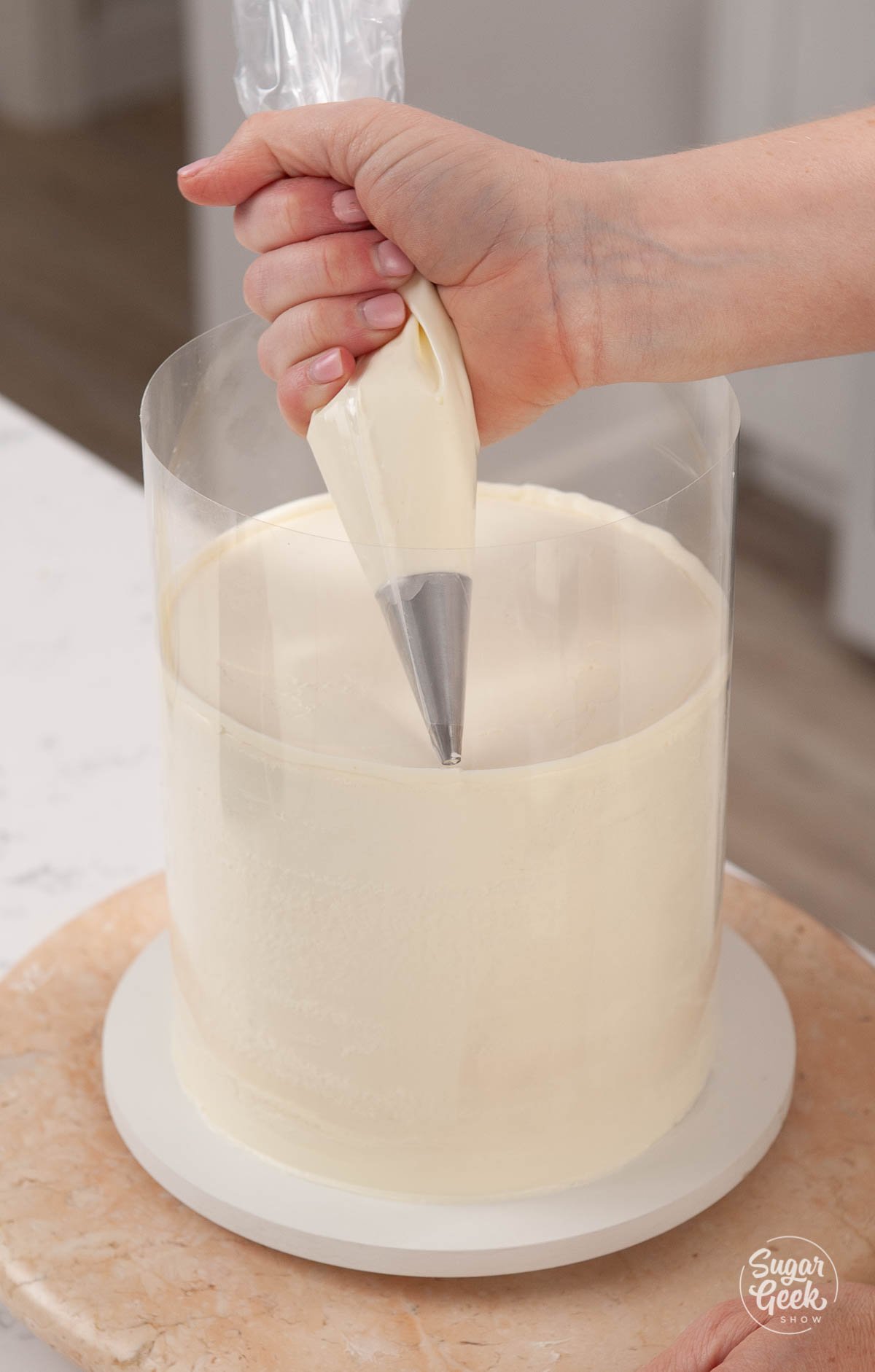 piping buttercream into the gap of the cake