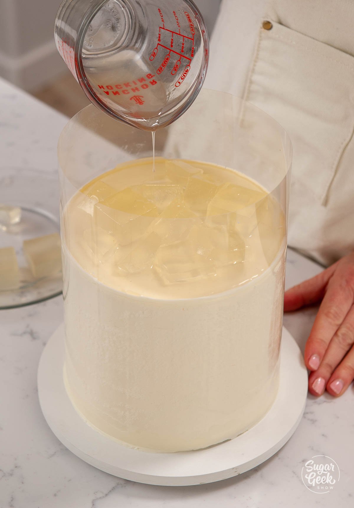 adding a thin layer of margarita gelatin to the top of the cake