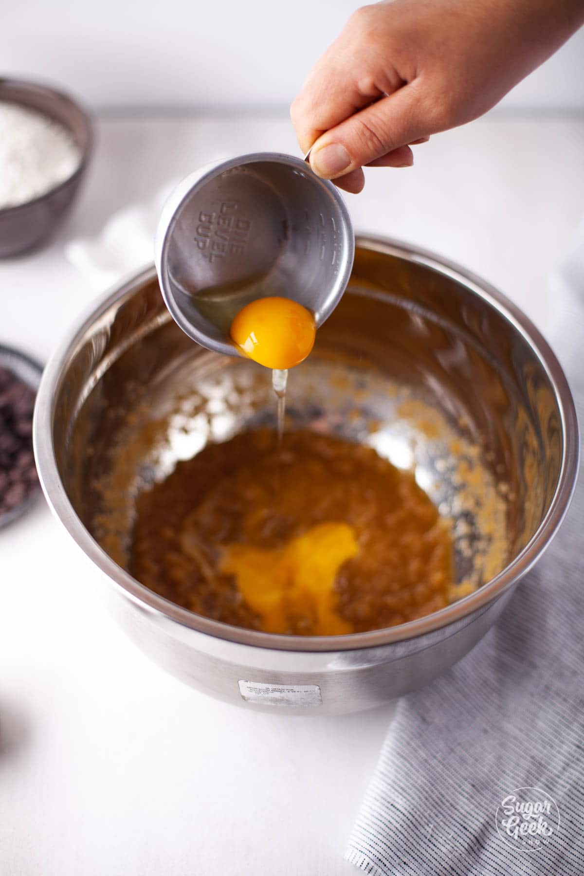 adding eggs to chocolate chip cookie mixture