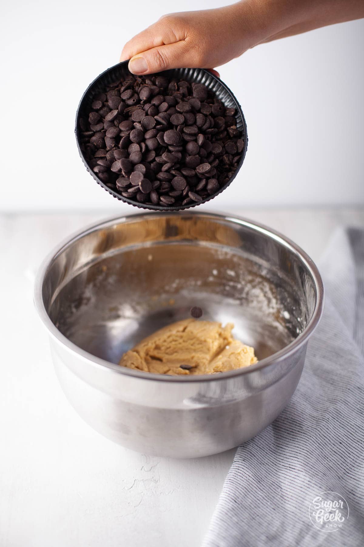 adding chocolate chips to the cookie batter