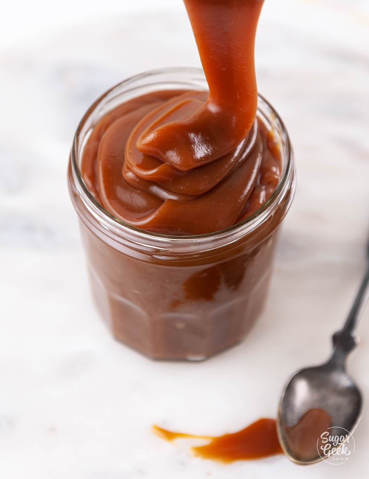 pouring caramel sauce into small glass container