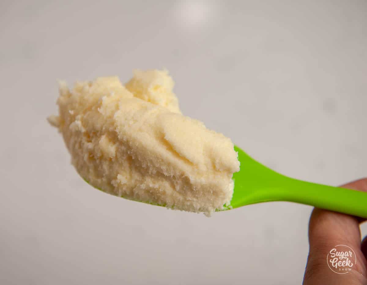 close up of creamed butter and sugar on a green spatula
