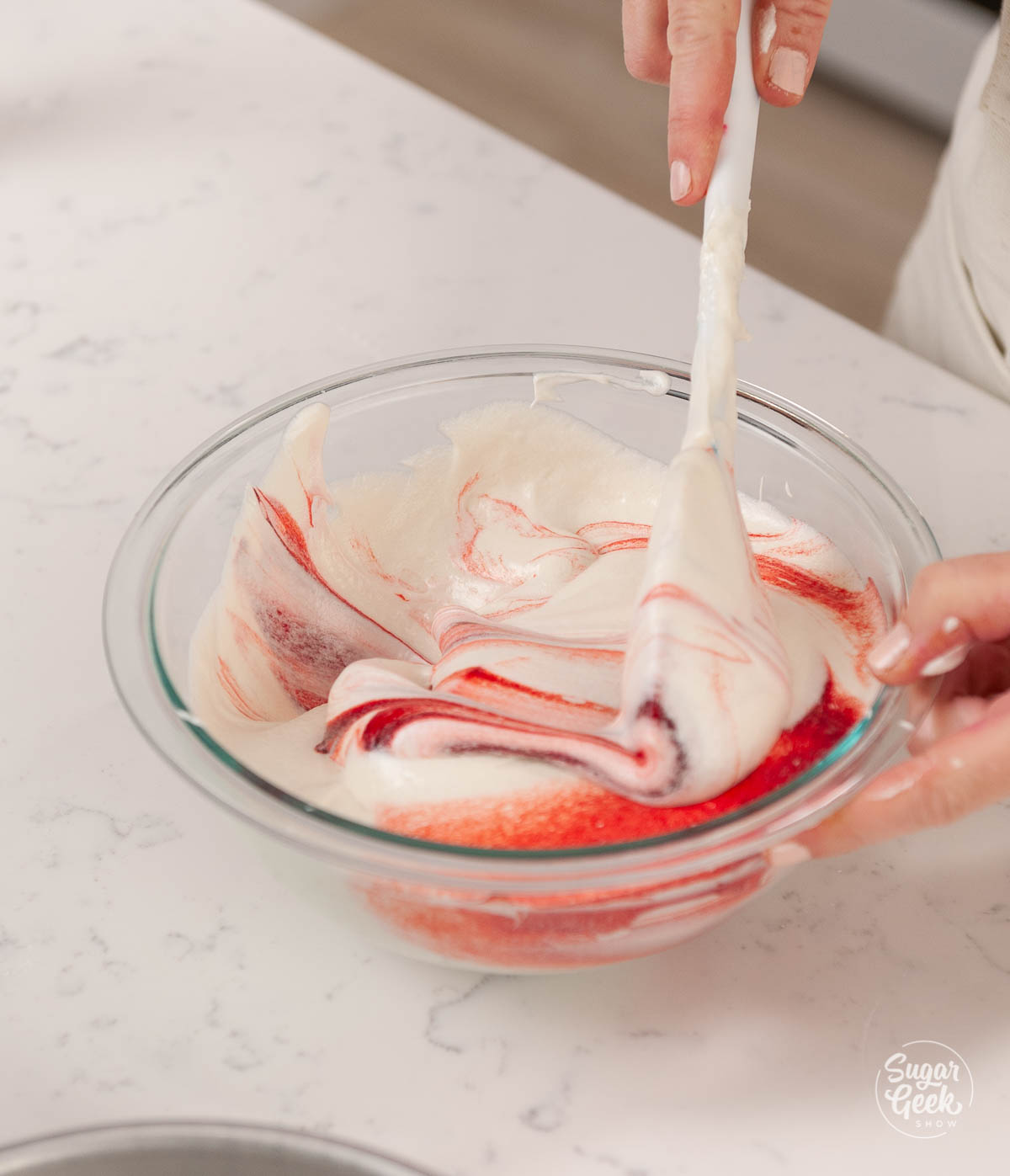 mixing red food coloring into white cake batter 
