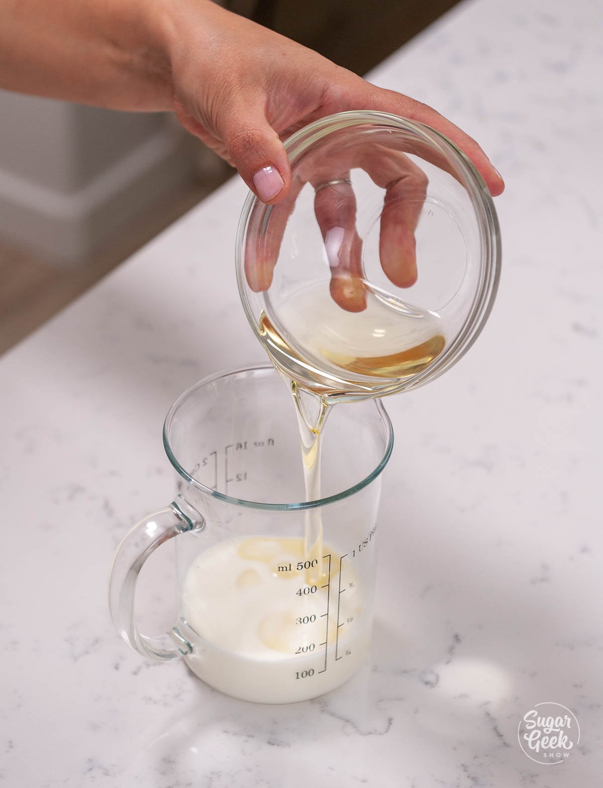 pouring oil into milk in a measuring cup