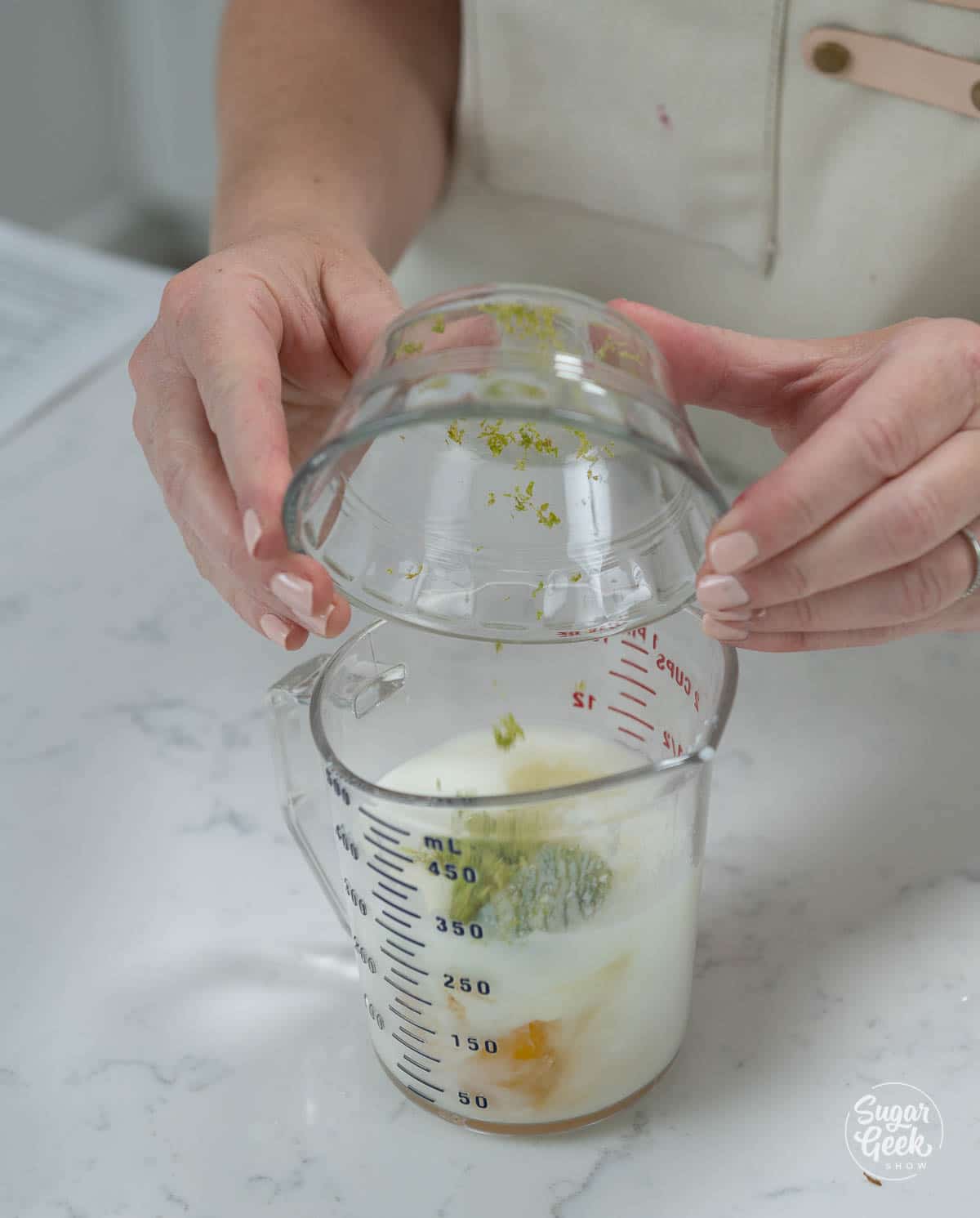 adding lime zest to buttermilk and eggs in a measuring cup