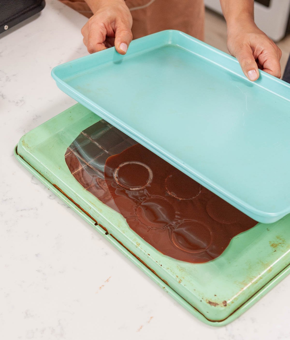 chocolate on acetate between two sheet pans