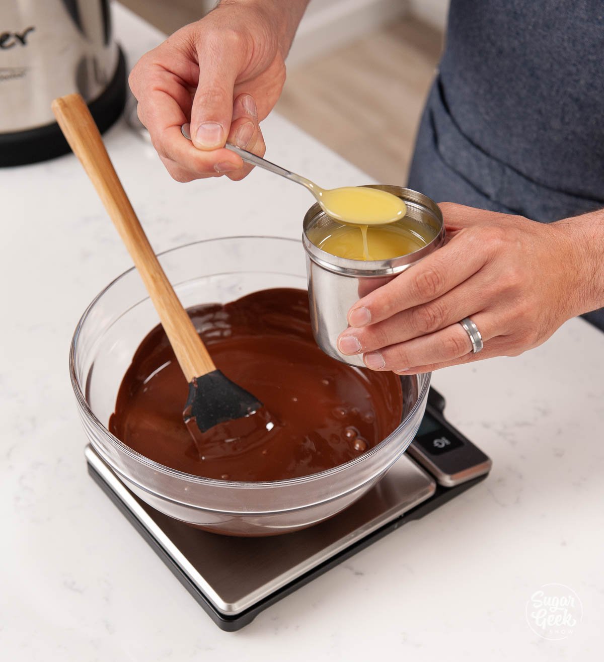 adding tempered cocoa butter to melted chocolate