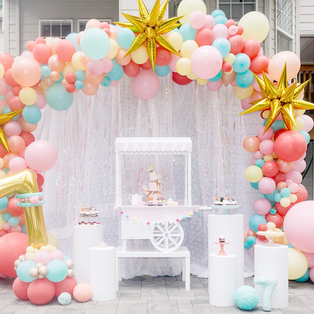 kittea party cake display with balloon arch