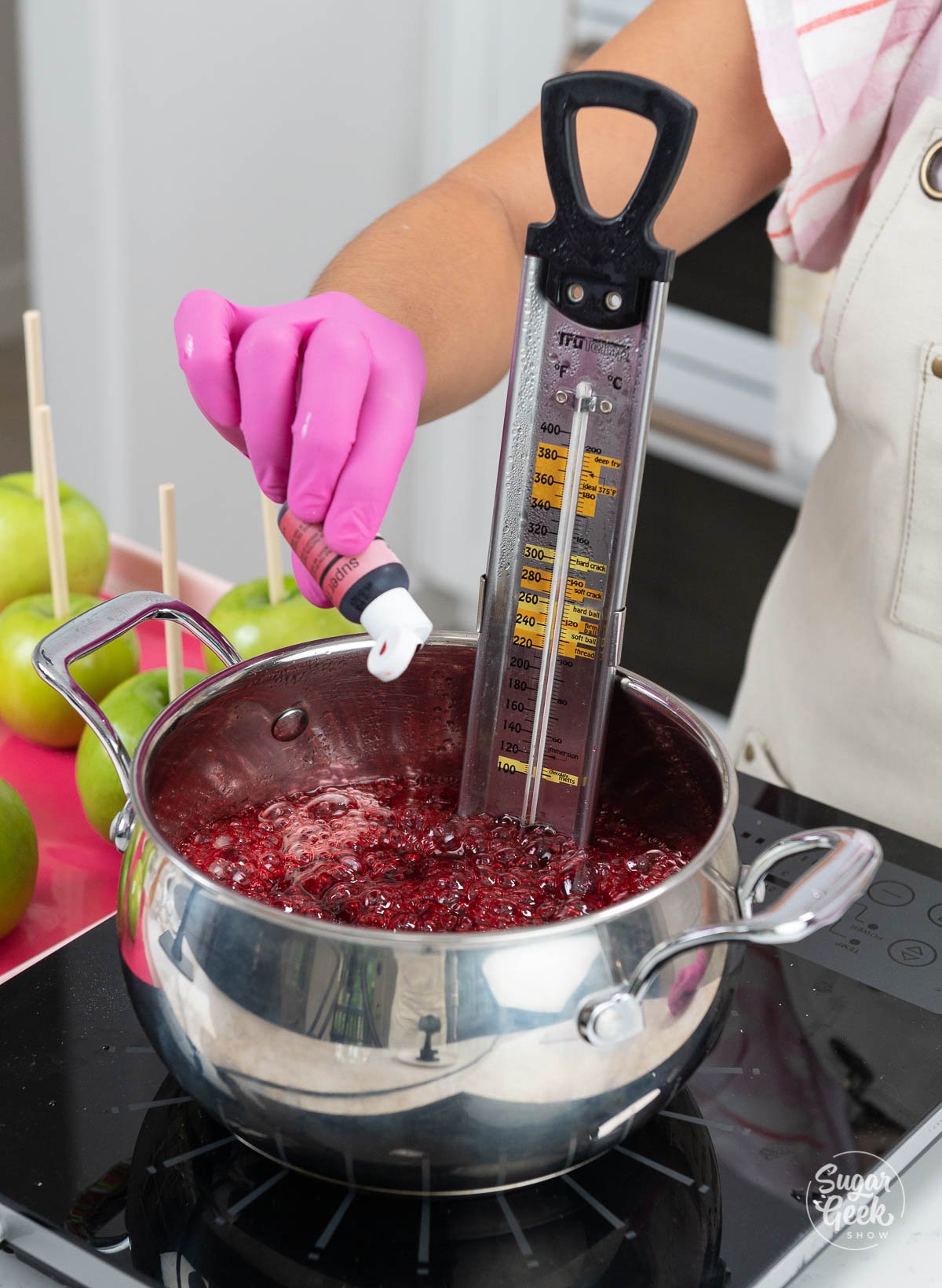 adding red food coloring to candy apple mixture