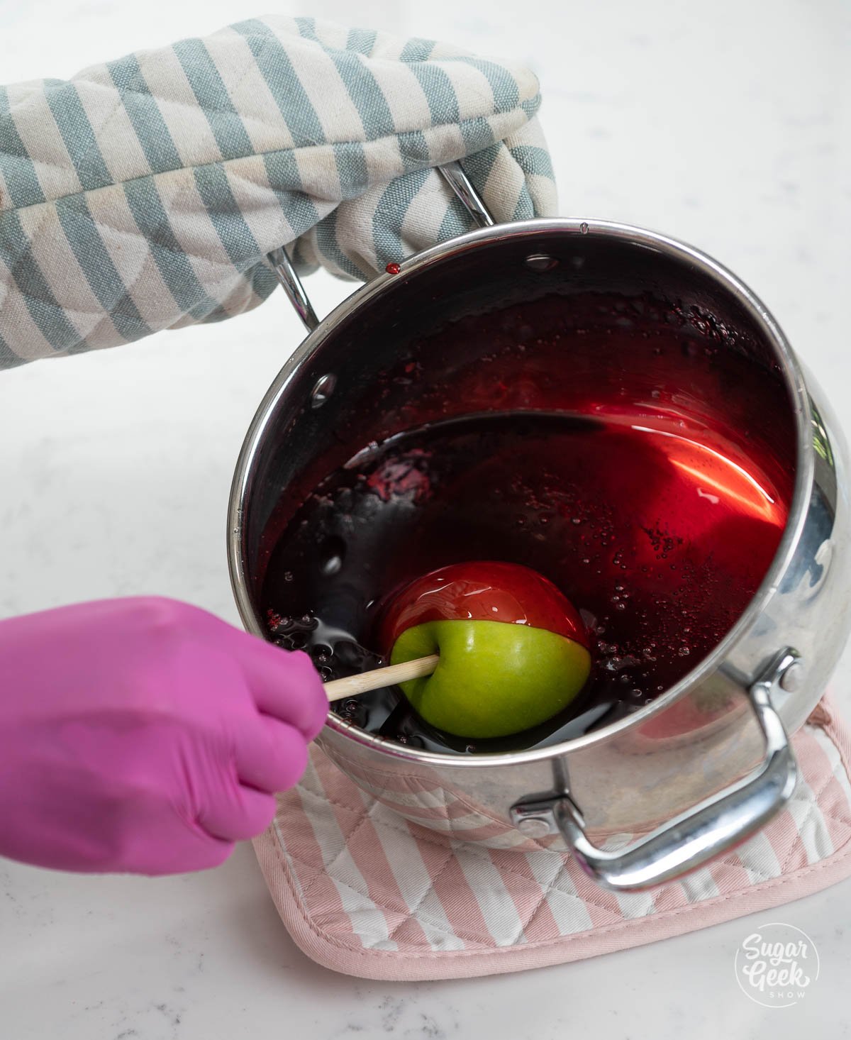 dipping a green apple in candy apple mixture