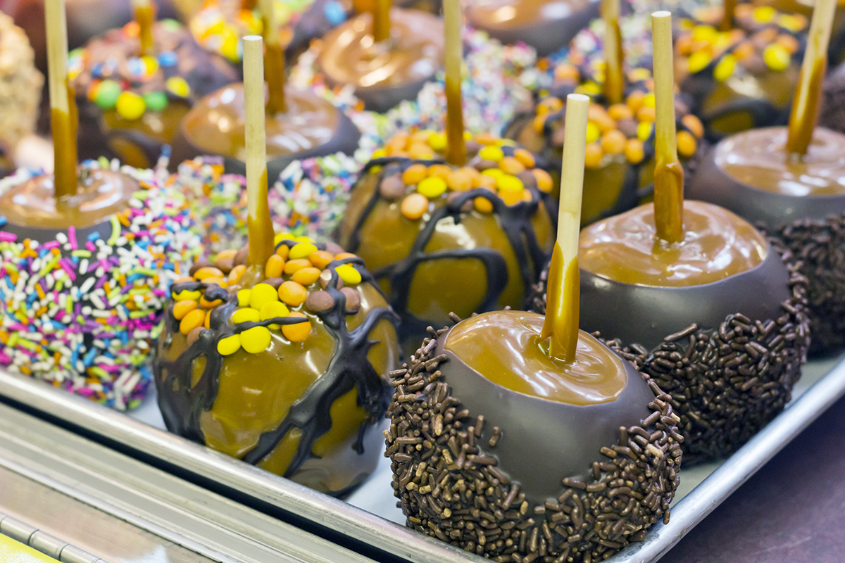 Caramel covered apples with sprinkles and candy garnishes.