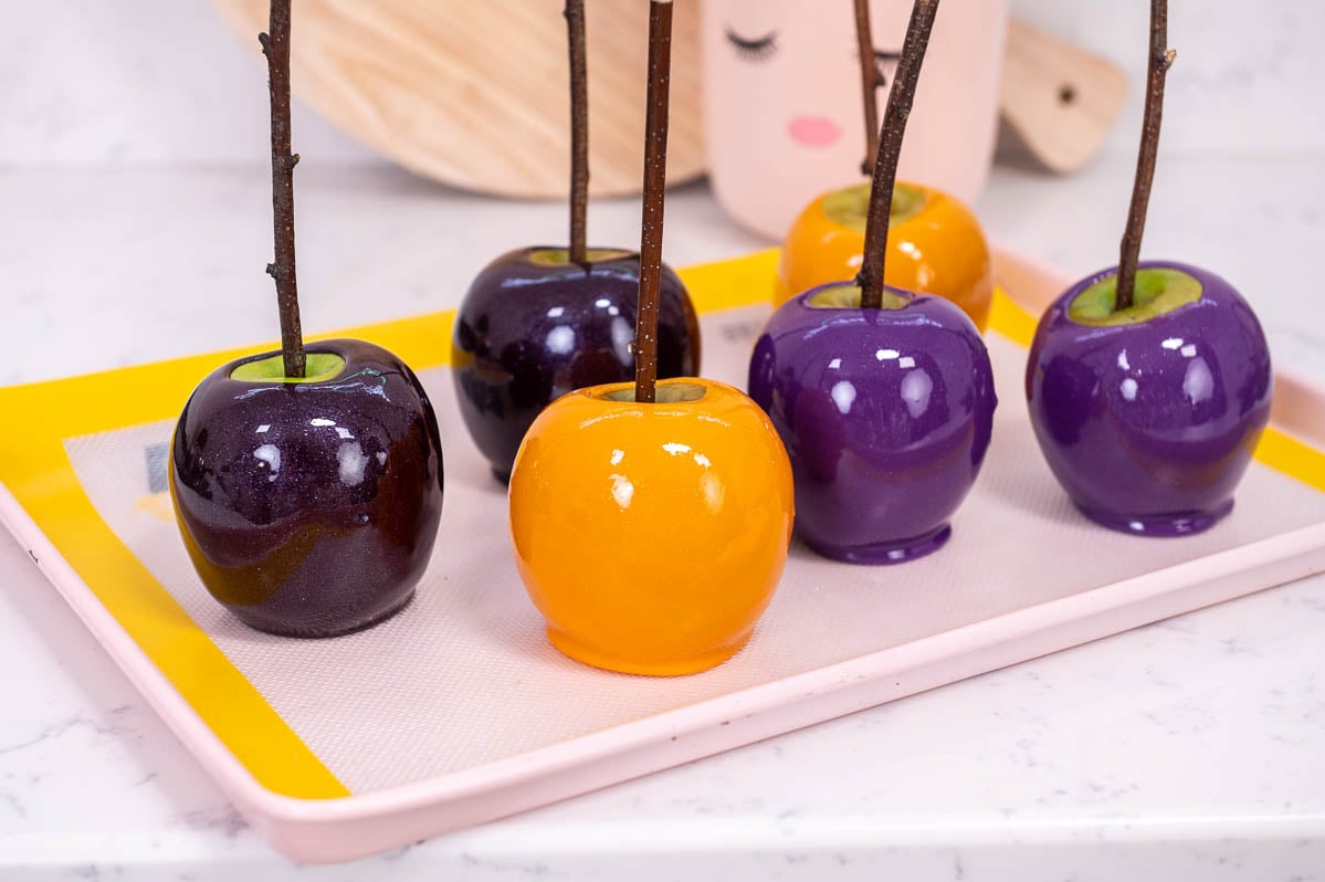 Yellow and purple candy apples on a silicone mat.