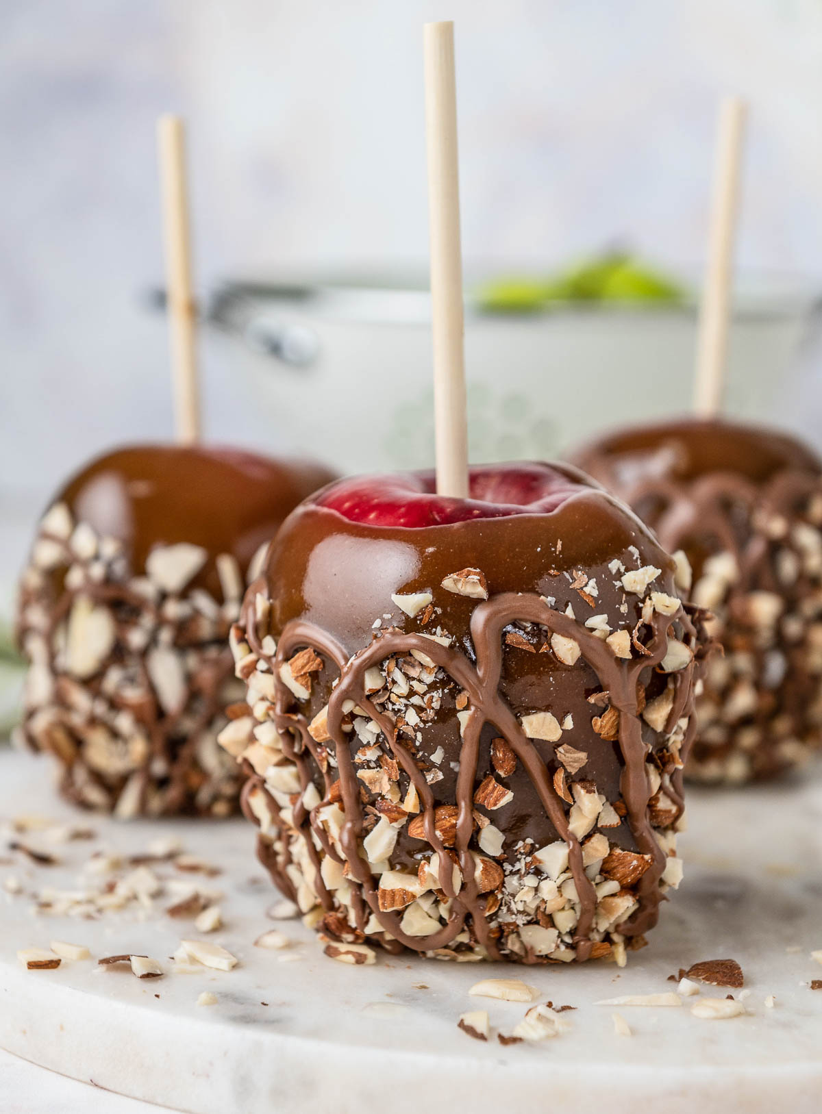 closeup of caramel apples with chopped nuts and chocolate