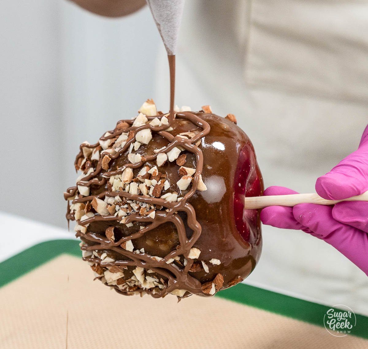 drizzling chocolate on caramel apples