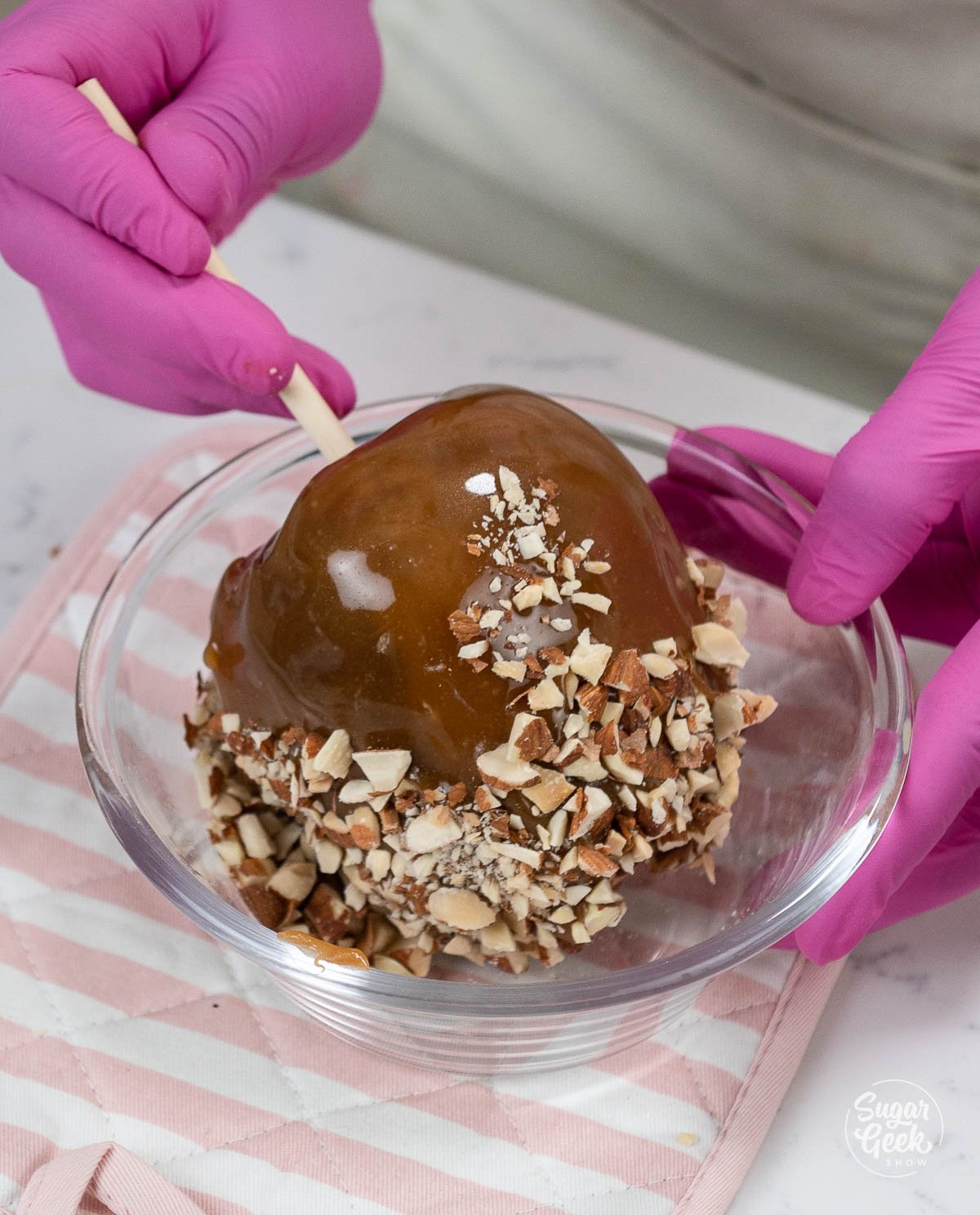 adding toppings to caramel apples