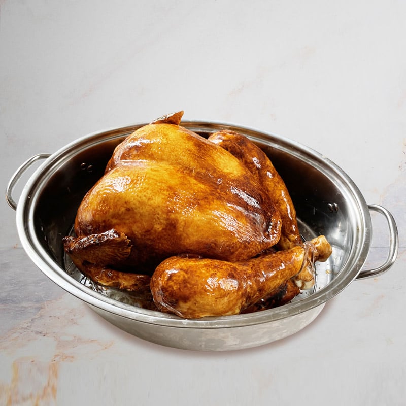 Cake sculpted to look like a realistic turkey sitting in a roasting pan