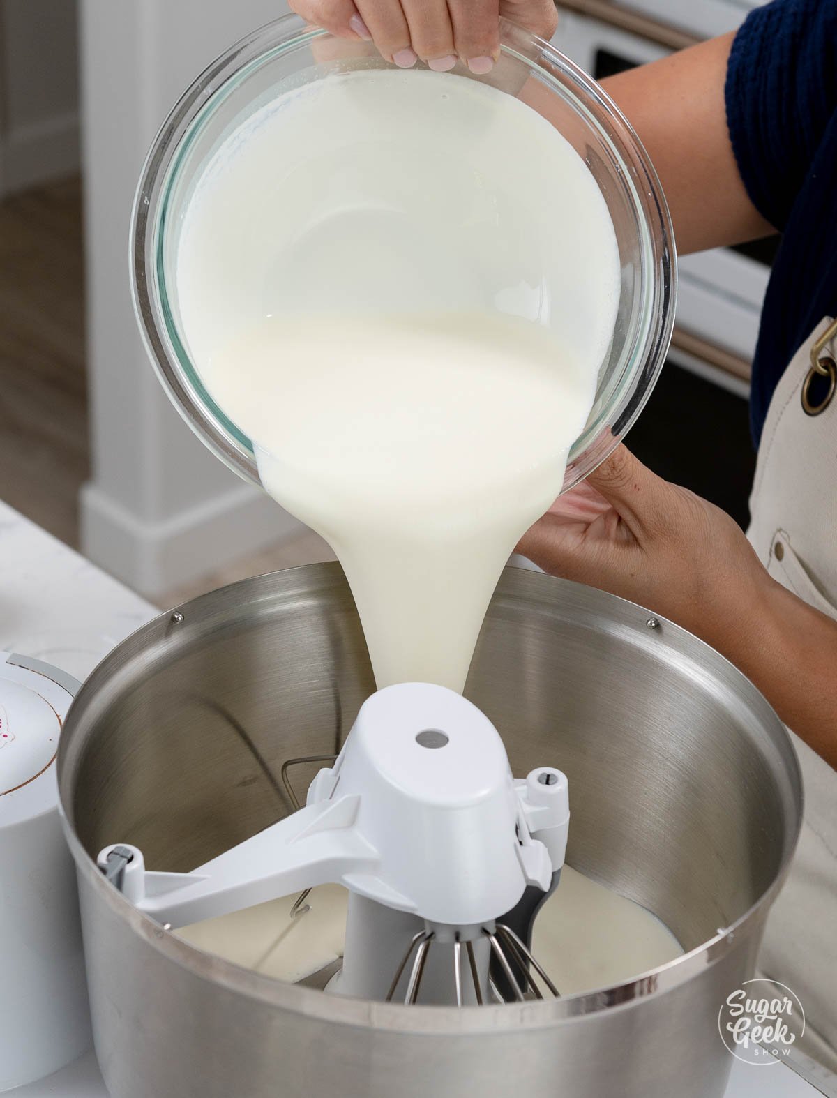 adding heavy cream to the bowl of a stand mixer