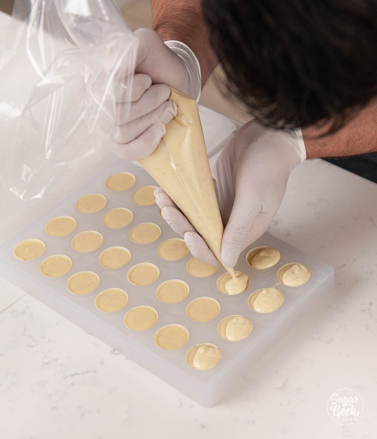 piping chocolate ganache onto the back of your bonbon mold