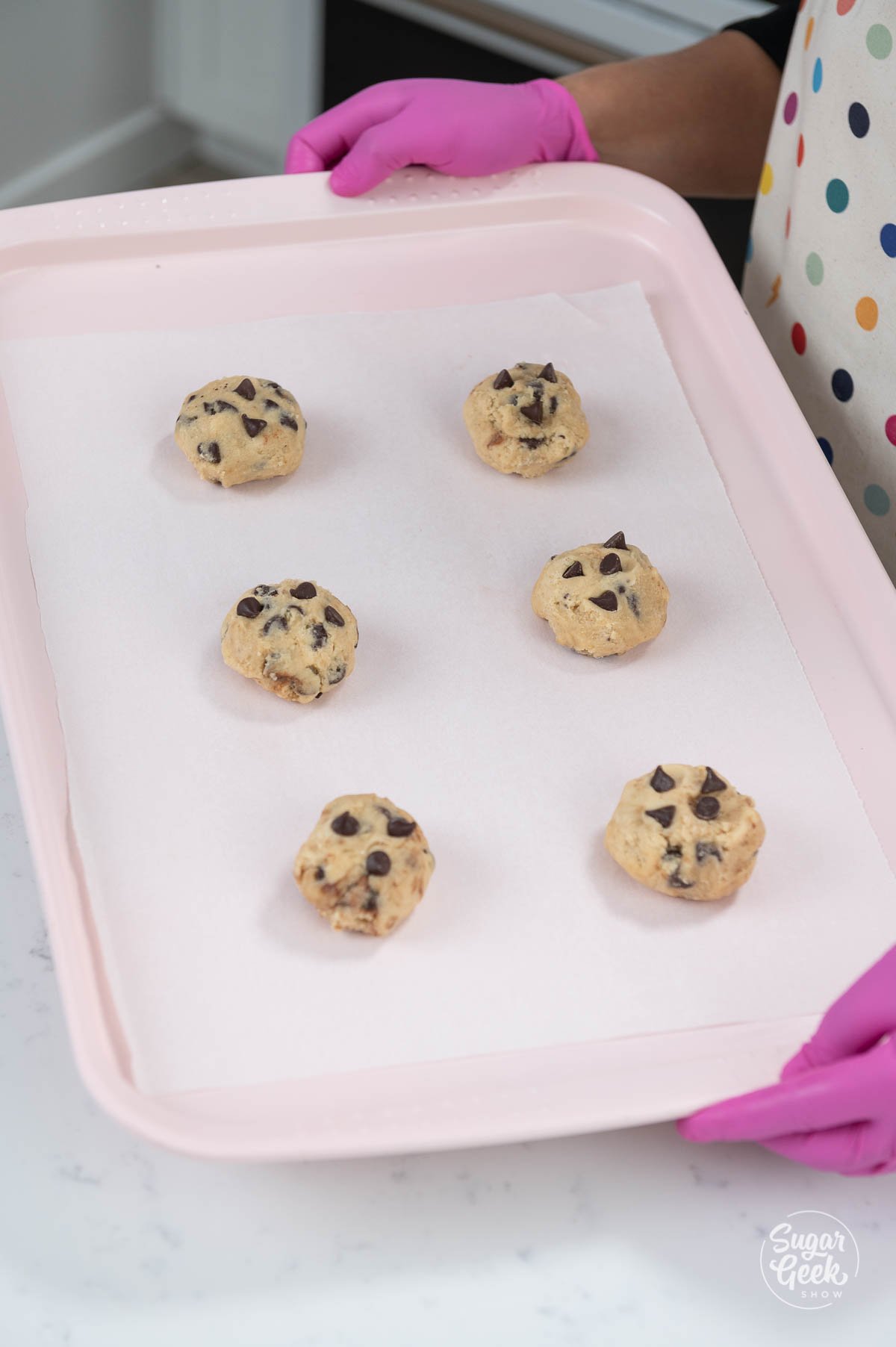 adding chocolate chips to the top of cookie dough