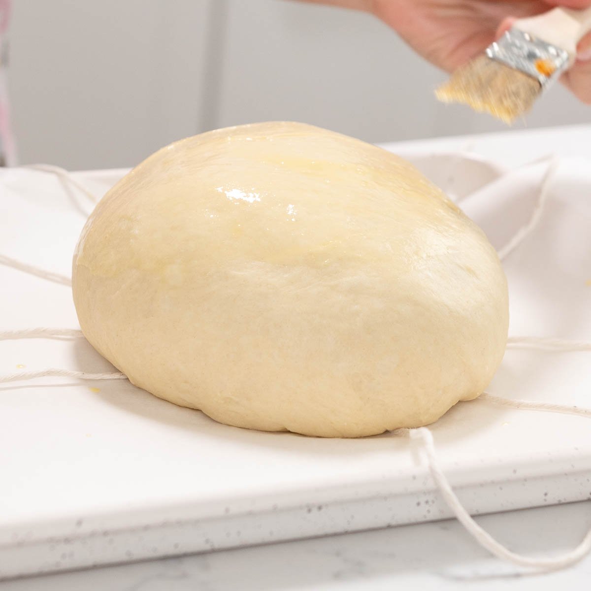 bread dough on top of bakers twine on a sheet pan
